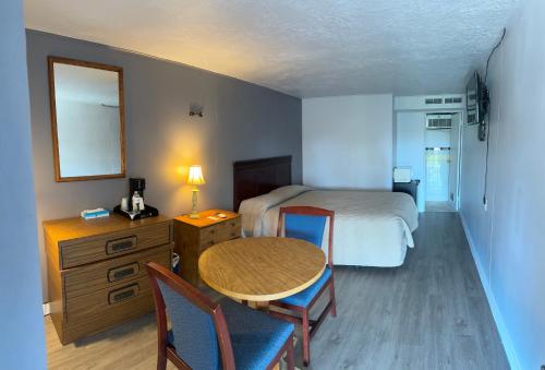 a hotel room with a bed and a table and chairs at Hopwood Motel in Uniontown