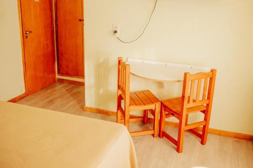 une chambre avec deux chaises en bois et une table dans l'établissement HOTEL REALICO, à Realicó