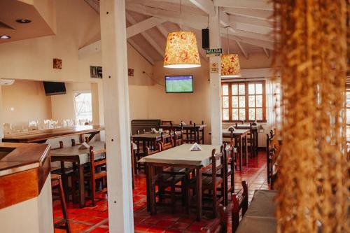 comedor con mesas y sillas y TV en HOTEL REALICO en Realicó