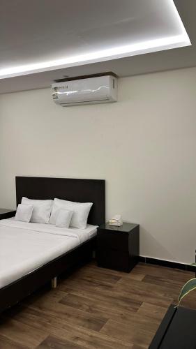 1 dormitorio con 1 cama con pared blanca en غرفه وصاله بدخول ذاااتي, en Riad
