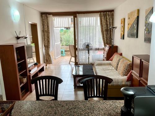 un soggiorno con divano, tavolo e sedie di Primavera a Costa Del Silencio