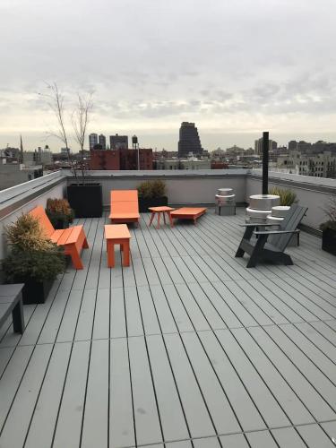 a deck with tables and benches on a roof at NY studio in New York