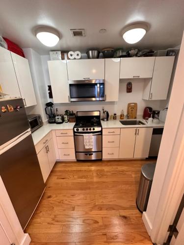 a kitchen with white cabinets and a stove top oven at NY studio in New York