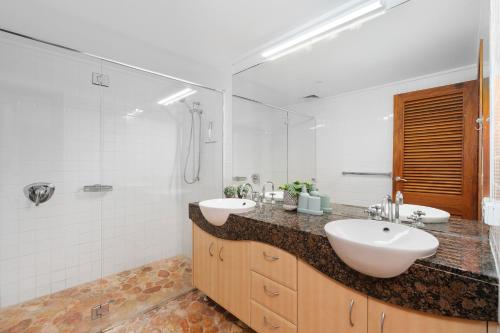 a bathroom with two sinks and a shower at Cove Point in Noosa Heads