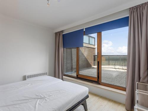 ein Schlafzimmer mit einem Bett und einem großen Fenster in der Unterkunft Prestige I 3 bedrooms on floor 10 in Middelkerke