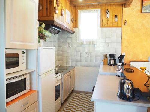 La cuisine est équipée d'un réfrigérateur blanc et d'un four micro-ondes. dans l'établissement Chalet by Mont Ventoux with Stunning Views, à Bédoin