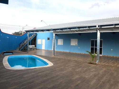 ein blaues Gebäude mit einem Pool und einer Terrasse in der Unterkunft Espaço céu Azul in Ribeirão Preto