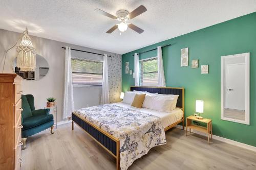 1 dormitorio con cama y pared verde en MODERN KING BED HOME CLOSE TO THE BEACH AND STORES. QUIET NEIGHBORHOOD AND PET FRIENDLY! en Jensen Beach