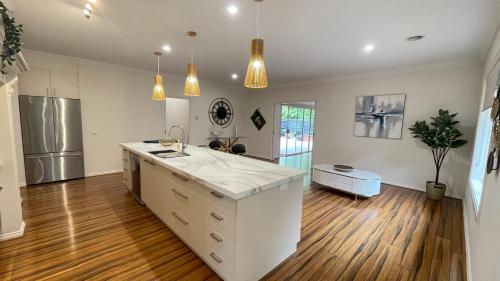 una cucina con piano di lavoro bianco e frigorifero di StayAU 4BRM Chic Urban Retreat a Officer