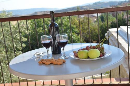 Vouni的住宿－沃尤尼旅舍，一张桌子,上面放着两杯葡萄酒和一盘水果