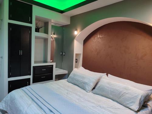 um quarto com uma cama grande e um tecto verde em Facturamos Elegante depto. confort limpieza em Atlacomulco de Fabela