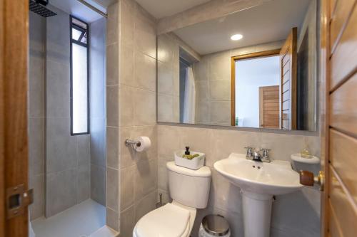 a bathroom with a toilet and a sink and a mirror at Parque 93, Suite 402 ,Chic Arty Retreat for 4 in Bogotá