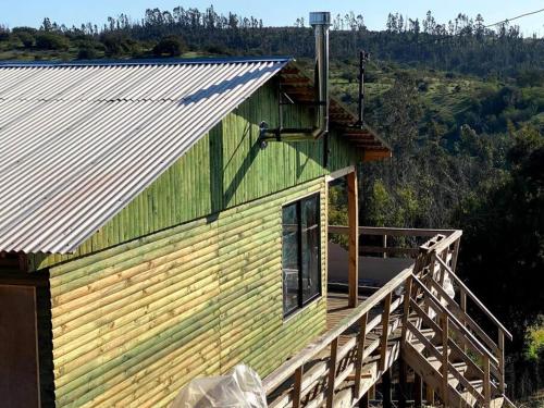 een huis met een metalen dak en een balkon bij Acogedora Cabaña in Cartagena