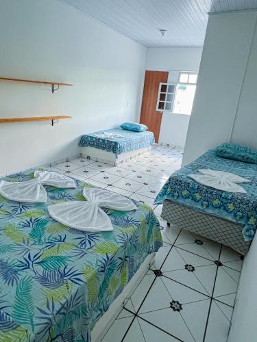 um quarto com 2 camas e piso em azulejo em Pousada Sempre Viva Lençóis em Lençóis