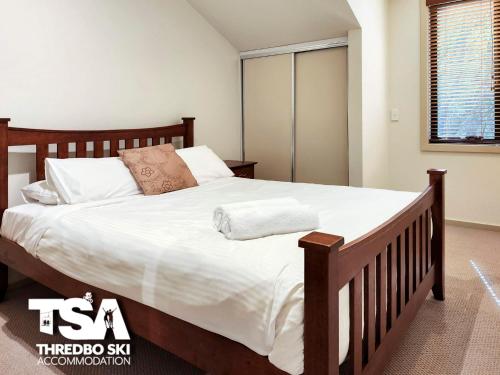 ein Schlafzimmer mit einem großen Bett mit weißer Bettwäsche in der Unterkunft Pagano 4 in Thredbo