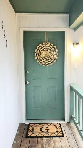 a green door with a chandelier in front of it at Sparkling Fresh Soldier's Pad 7 Mi to Fort Bragg in Fayetteville