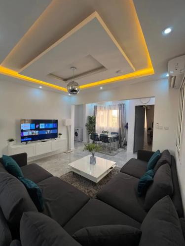sala de estar con sofá grande y TV en American House en Accra
