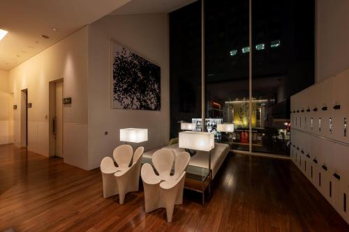 een woonkamer met stoelen en een tafel en een bank bij remm Hibiya in Tokyo