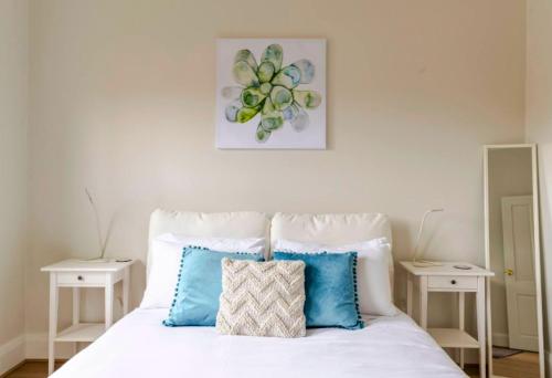 ein Schlafzimmer mit einem weißen Bett mit blauen Kissen in der Unterkunft Stylish Villa in Nailsworth By Host Solutions in Broadview