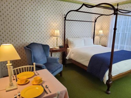 a hotel room with a bed and a table and a chair at Harbourside Inn in Northeast Harbor