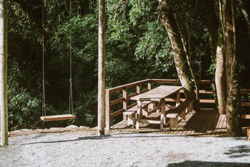 a picnic table and a swing in a park at Morada encanto da cachoeira in Aguas Mornas