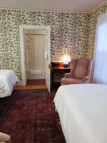 a bedroom with a bed and a chair in a room at Harbourside Inn in Northeast Harbor