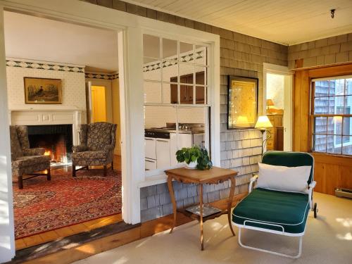 a living room with a chair and a table and a fireplace at Harbourside Inn in Northeast Harbor