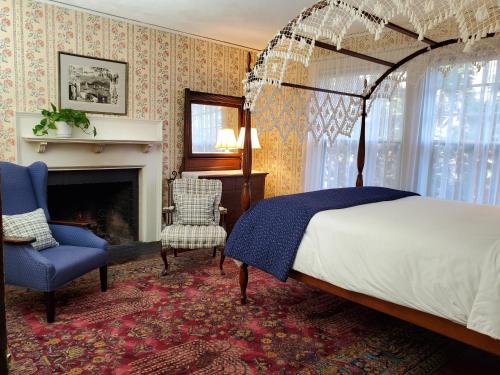 a bedroom with a canopy bed and a fireplace at Harbourside Inn in Northeast Harbor