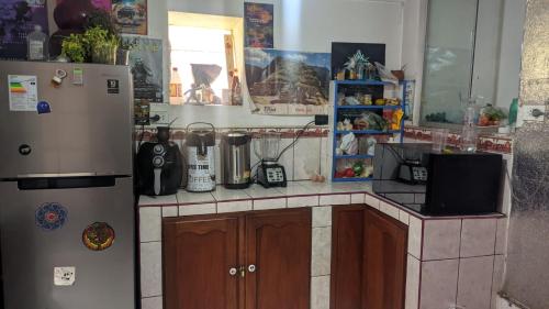 a kitchen with a refrigerator and a counter top at Aguaymanto pisac hostel in Pisac