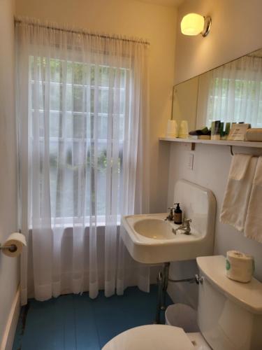 a bathroom with a sink and a toilet and a window at Harbourside Inn in Northeast Harbor