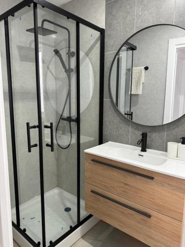 a bathroom with a shower and a sink and a mirror at UIM Mediterraneo ATICO Cendoya Wifi in Puerto de Sagunto
