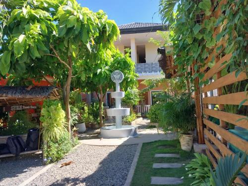 un jardín con un reloj en medio de un patio en SMAK's Hotel, en Bantayan Island