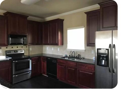 a kitchen with wooden cabinets and a stainless steel refrigerator at Serenity Suite in Grovetown