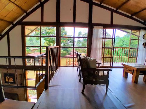 a living room with windows and a chair and a table at Casa Campo Valle De Cocora in Salento