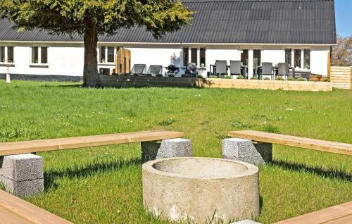 two wooden benches in a field with a house at 3 Bedroom Stunning Home In Løkken in Løkken