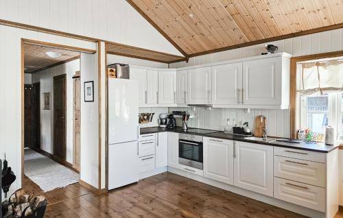 una cucina con mobili bianchi e soffitto in legno di 4 Bedroom Nice Home In Rauland a Rauland
