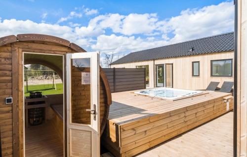 een houten gebouw met een hot tub op een terras bij Pet Friendly Home In Hadsund With Kitchen in Hadsund