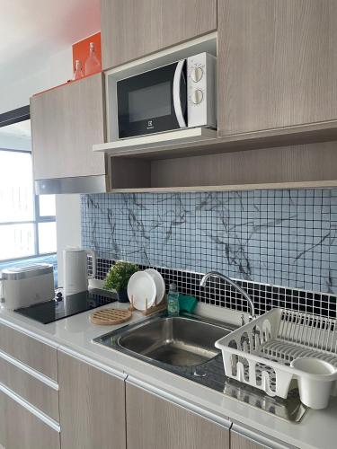 a kitchen with a sink and a microwave at Centrio Condominiums Top Floor with Pool and Garden view in Ban Na Khua