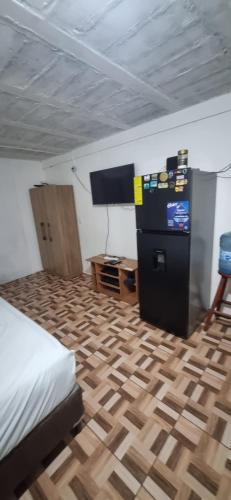 een slaapkamer met een bed en een flatscreen-tv bij apartamento pequeño amueblado in San Salvador