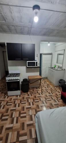 een keuken met een houten vloer en een kookplaat. bij apartamento pequeño amueblado in San Salvador