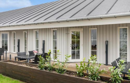 a house with a metal roof and a deck at Stunning Apartment In Væggerløse in Bøtø By