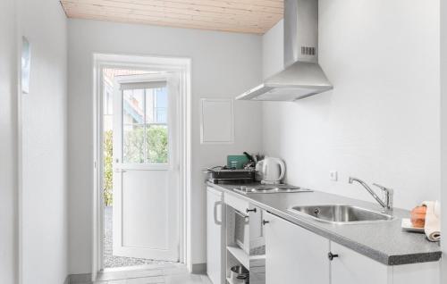 a white kitchen with a sink and a window at Stunning Apartment In Væggerløse in Bøtø By