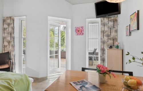 a room with a table and a dining room with a door at Stunning Apartment In Væggerløse in Bøtø By
