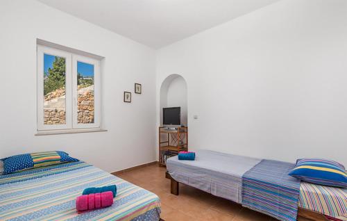 Duas camas num quarto com uma janela em 3 Bedroom Awesome Apartment In Jablanac em Jablanac