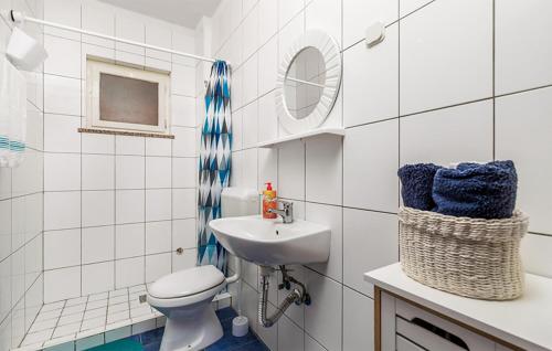 uma casa de banho branca com um WC e um lavatório em 3 Bedroom Awesome Apartment In Jablanac em Jablanac