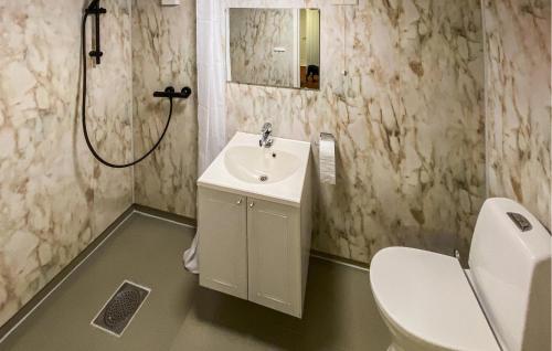 a white bathroom with a sink and a toilet at 5 Bedroom Amazing Home In Strandebarm in Strandebarm