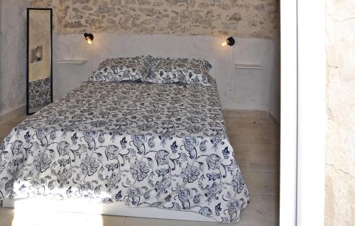 1 dormitorio con 1 cama con edredón blanco y negro en Le Gite Du Bastidon, en La Tour-dʼAigues