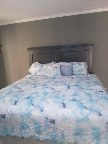 1 cama con edredón y almohadas azules y blancos en Country Manor, en Ocho Ríos