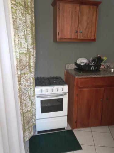 a kitchen with a white stove and a counter top at Country Manor in Ocho Rios