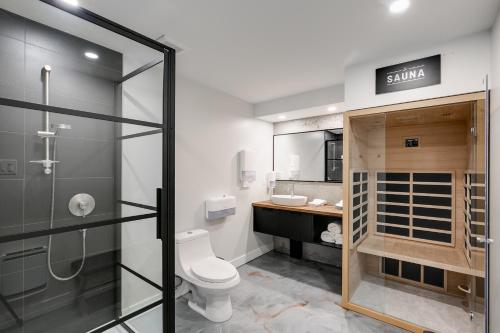 a bathroom with a shower and a toilet and a sink at Complexe La Voûte by Gestion ELITE in Laval